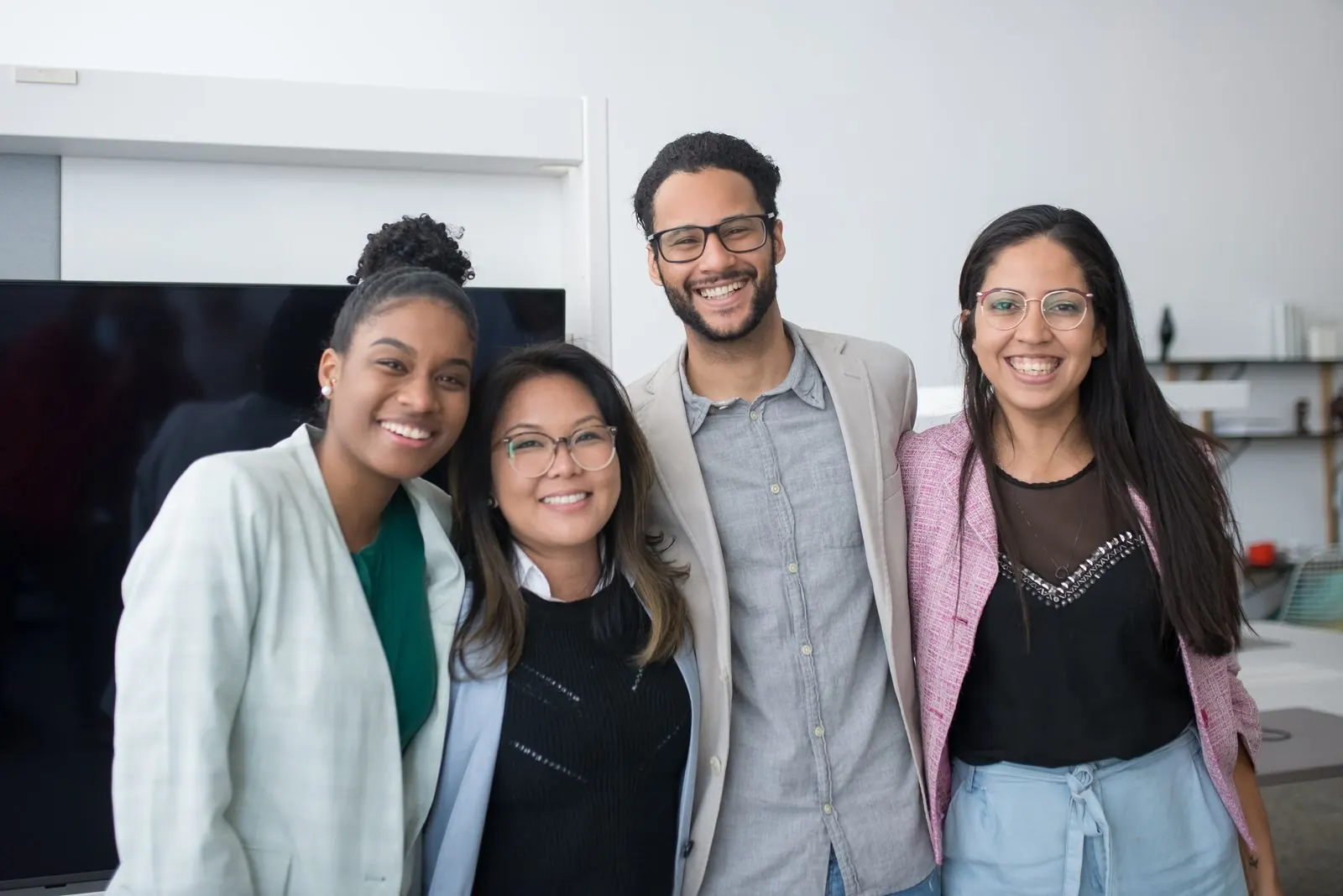 Four smiling colleagues posing together