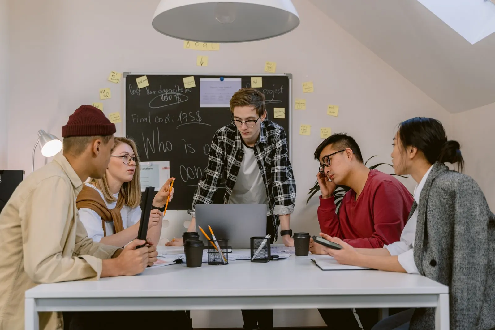 Colleagues brainstorming around a table with sticky notes