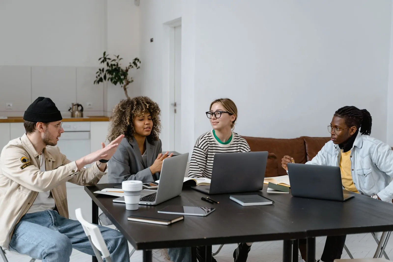 A team collaborating around a table with laptops