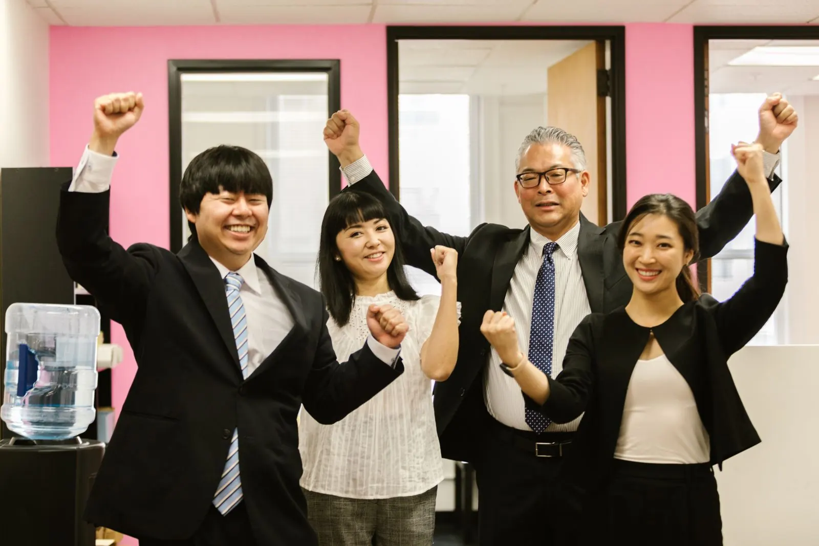 Colleagues celebrating with raised fists in the office