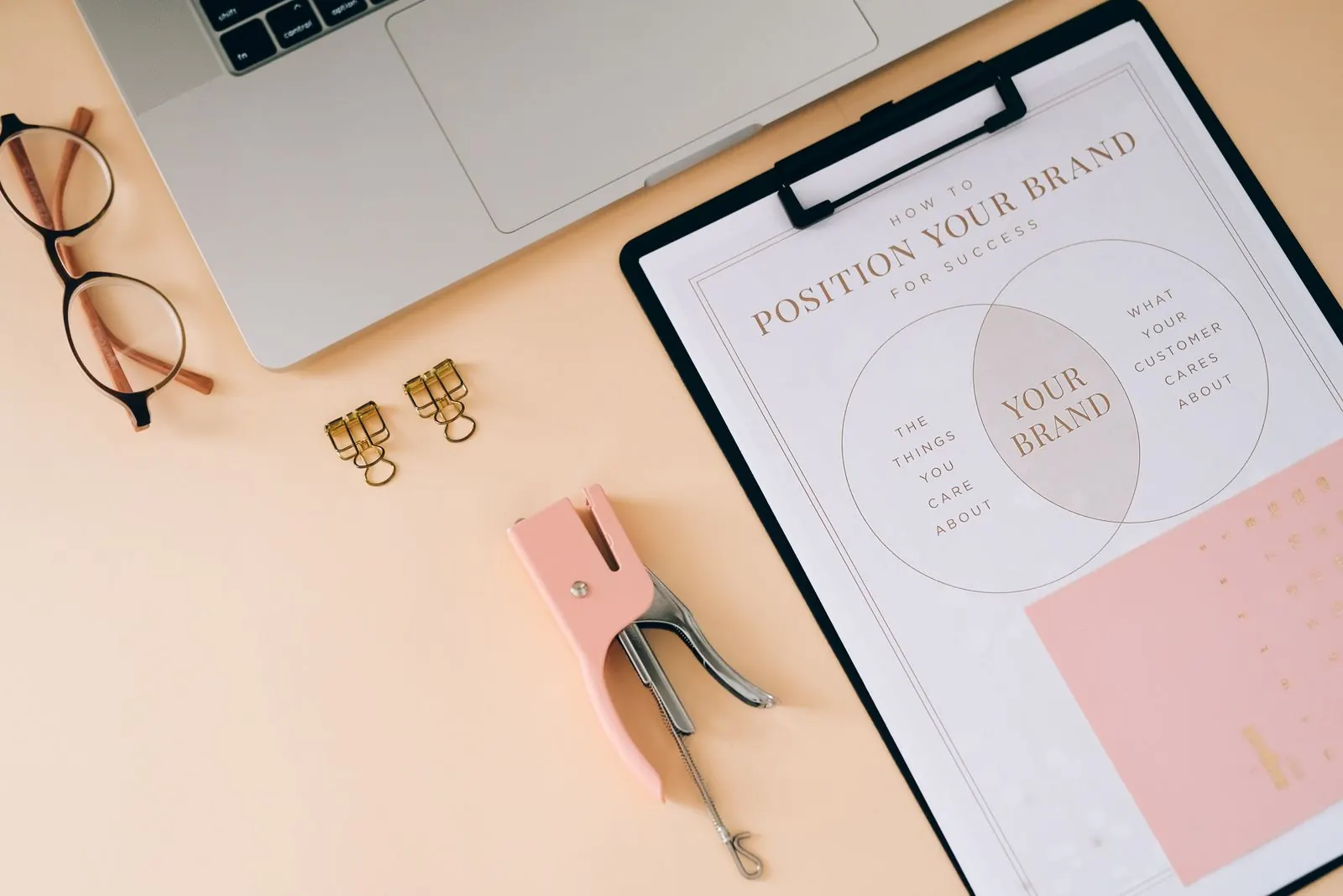 A brand positioning diagram on a clipboard on a designer's desk