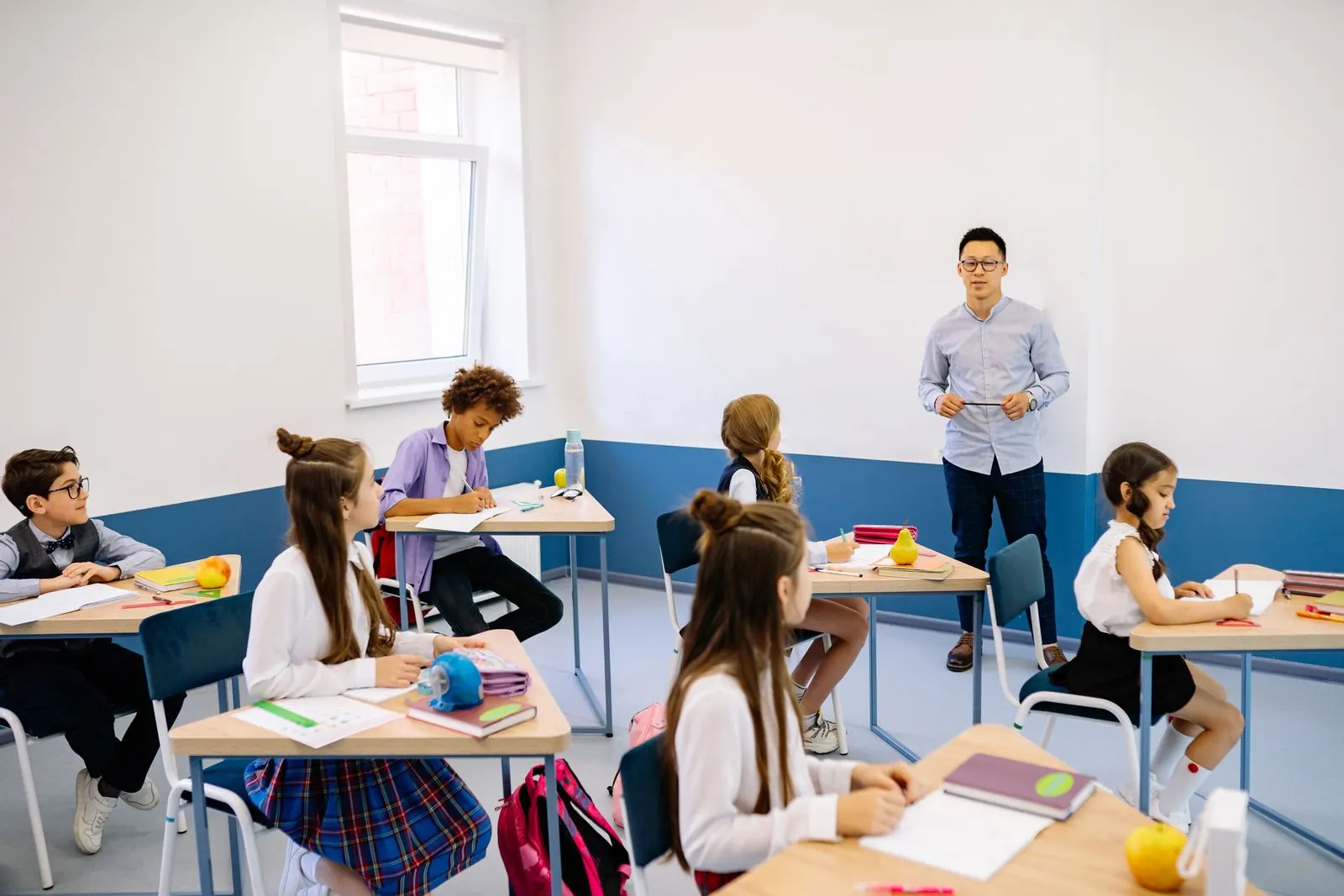 A teacher and students in a bright classroom