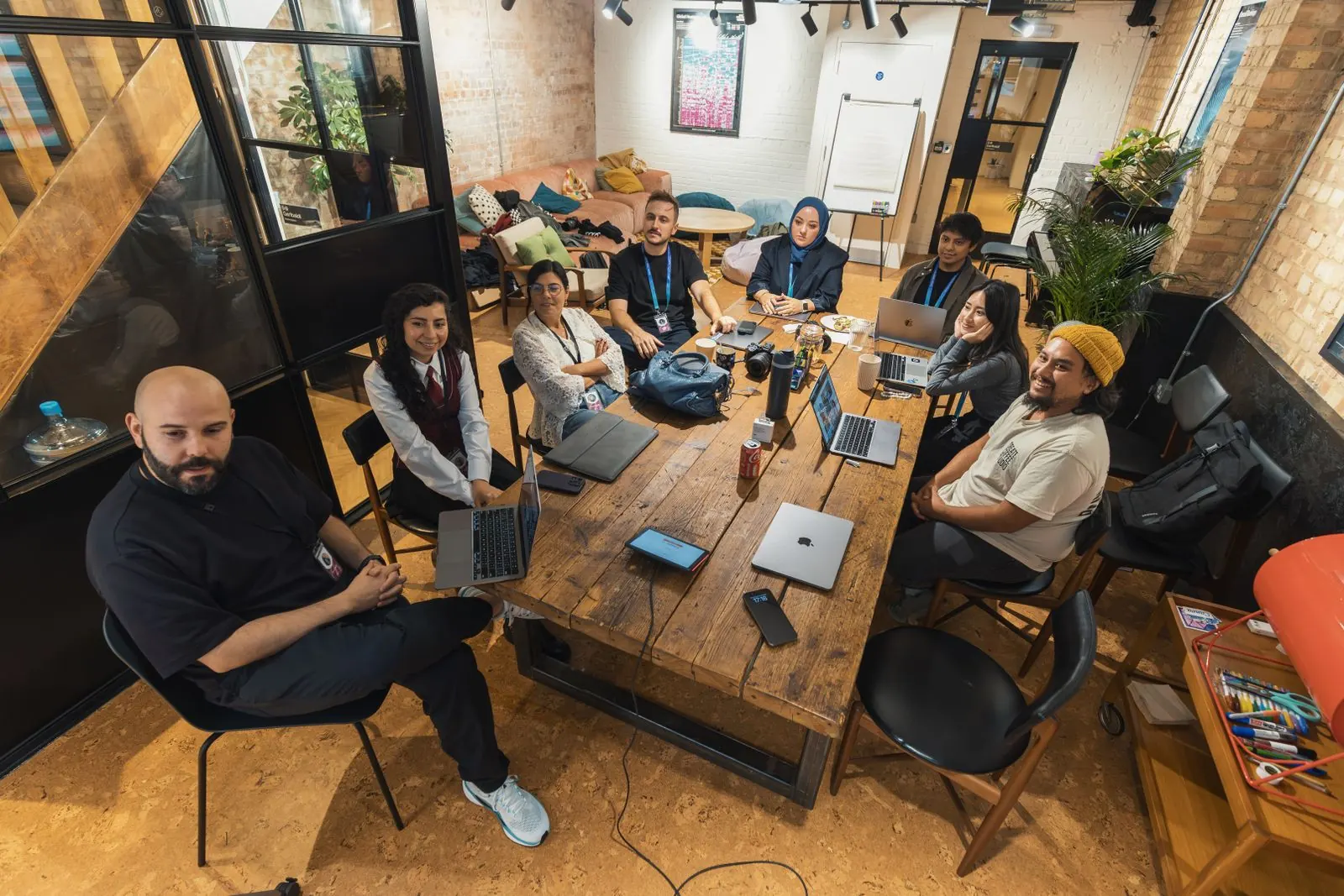 A diverse team meeting around a long table in a bright loft office